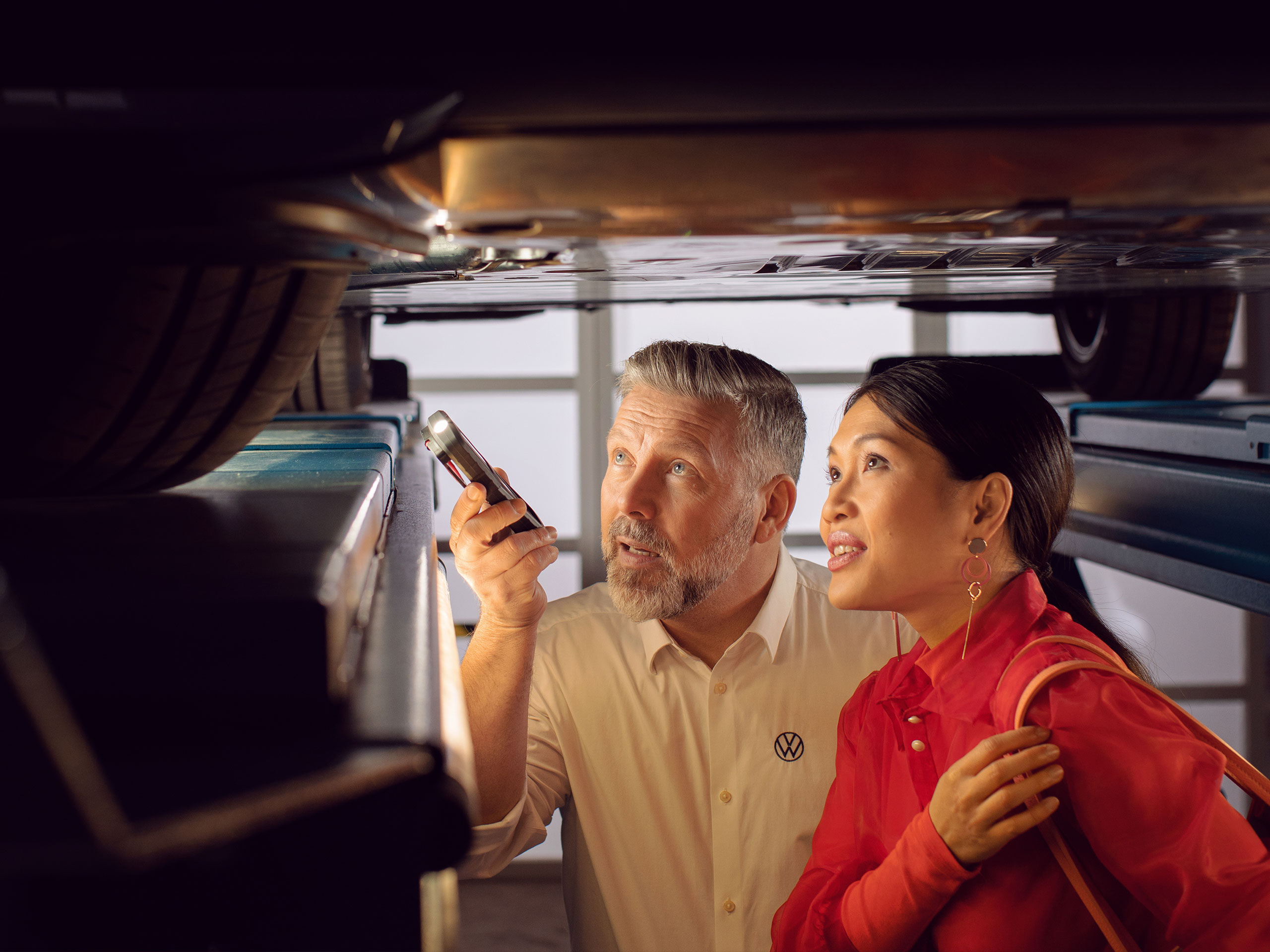 Un profesional del Servicio Oficial le muestra a una clienta algo sobre su coche eléctrico