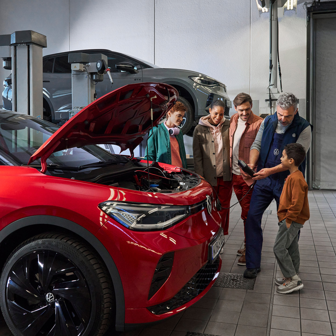 Una familia junto a un trabajador del servicio tecnico de Volkswagen
